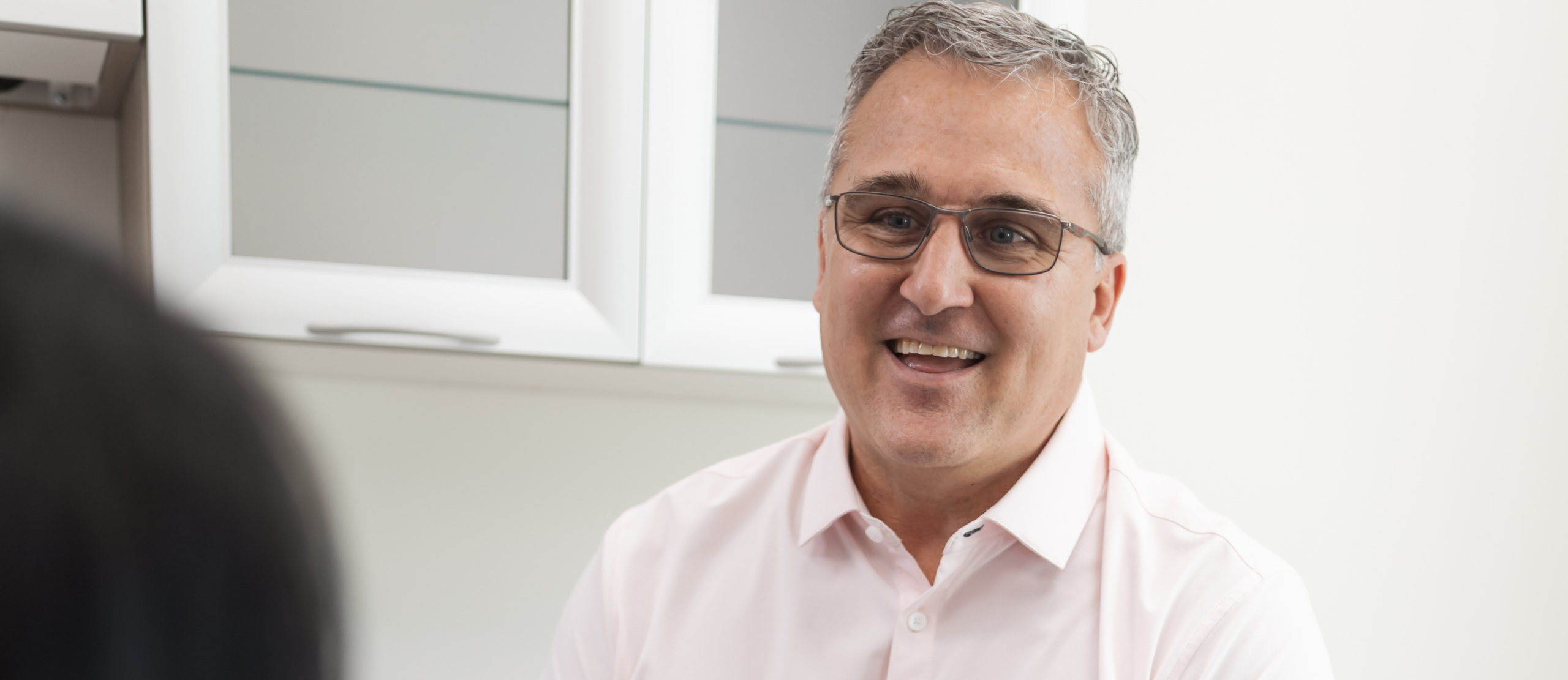 A man in glasses is engaged in conversation with a woman.