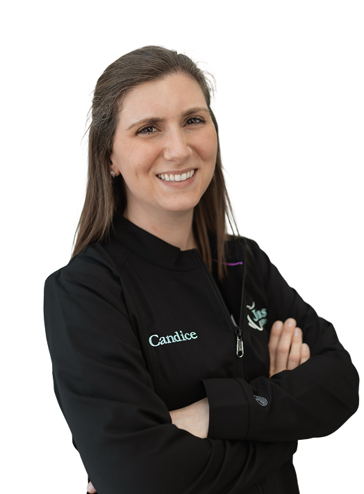 Smiling woman with long brown hair, wearing a black jacket with "Candice" embroidered on it, crosses her arms confidently against a black background.
